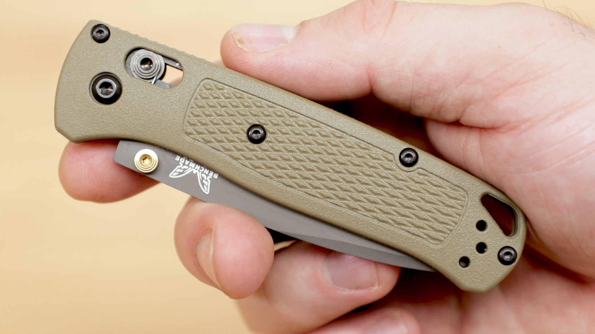 Benchmade Bugout with green handles and black blade shown closed in hand