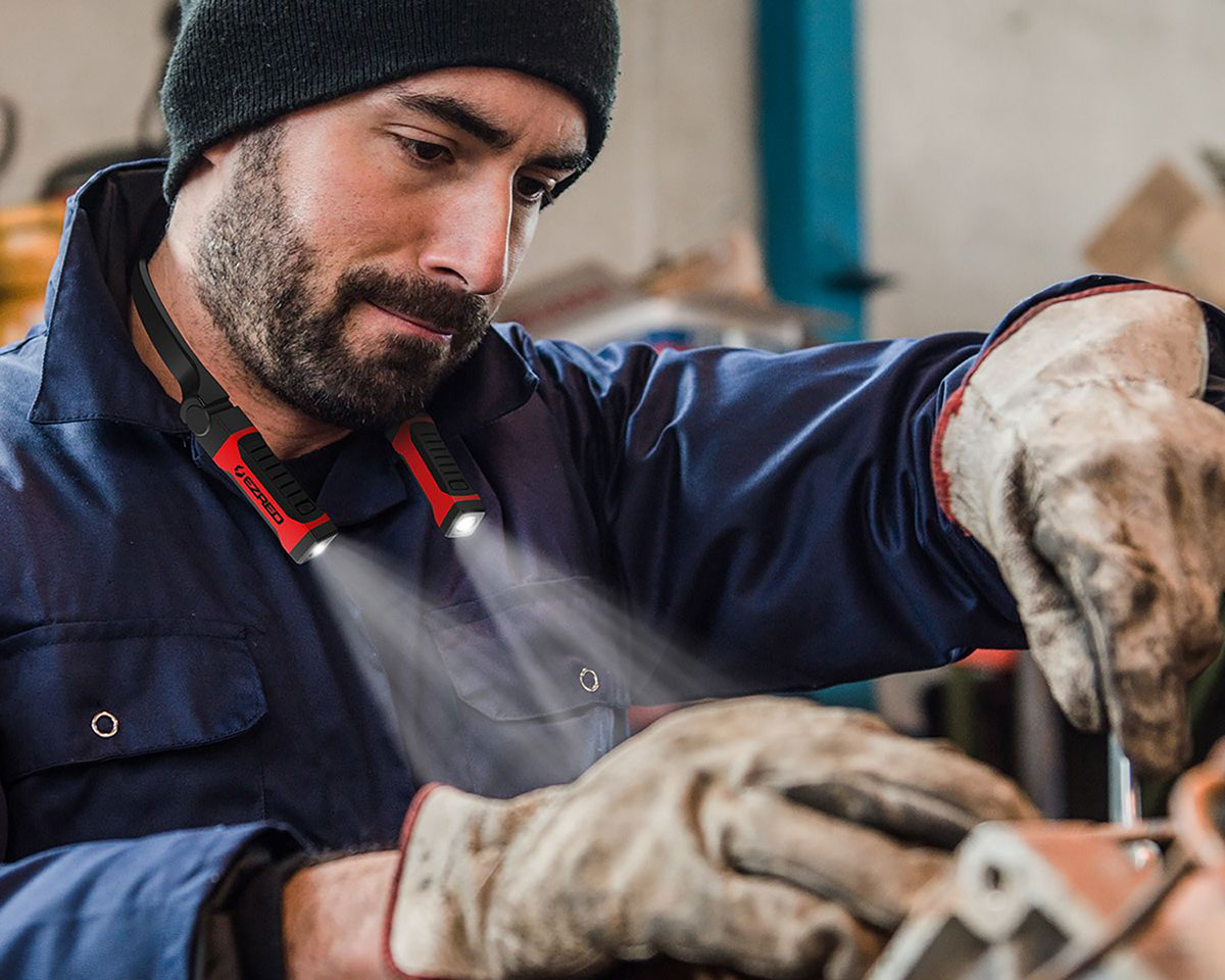 Man working with tools, wearing EZRED Neck light shining onto his work