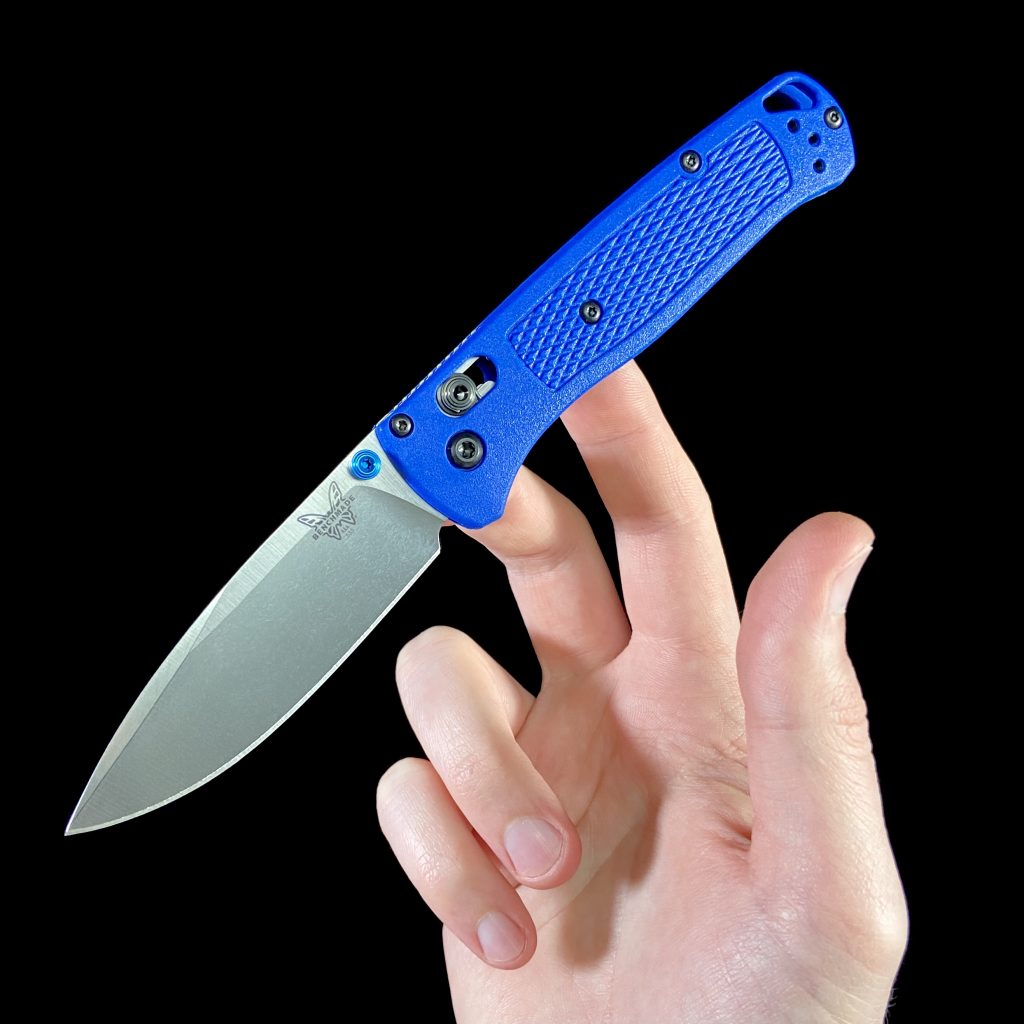 Benchmade Bugout folding knife with blue handles in hand