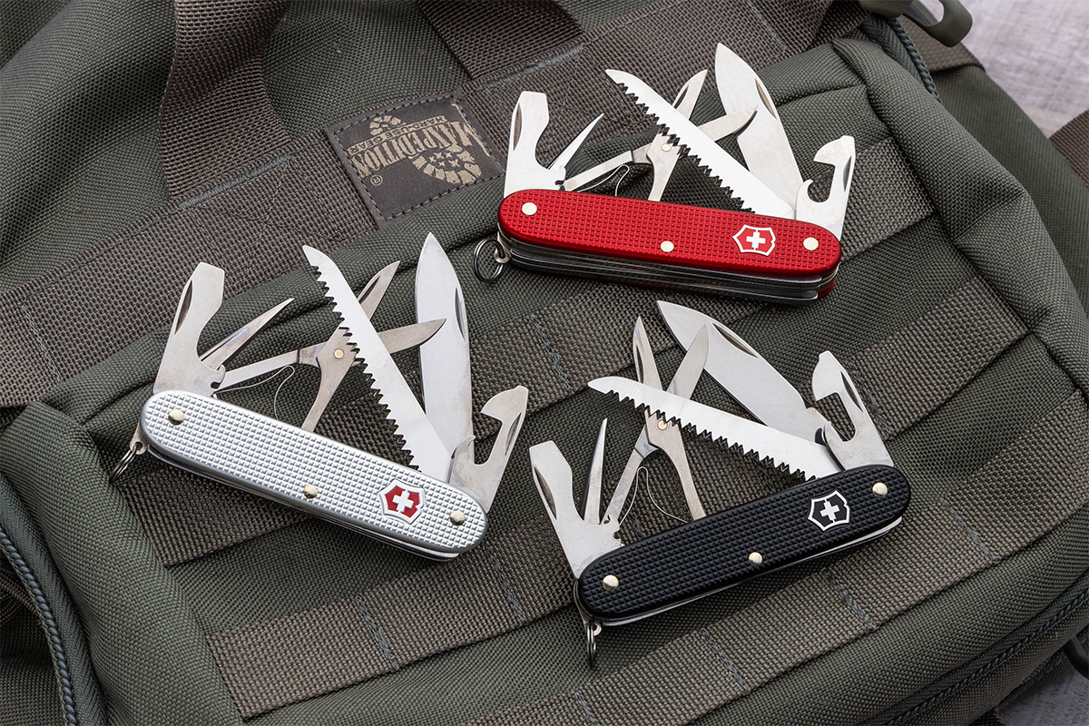 Victorinox Swiss Army Farmer X in silver, red, and black, open on a Maxpedition backpack