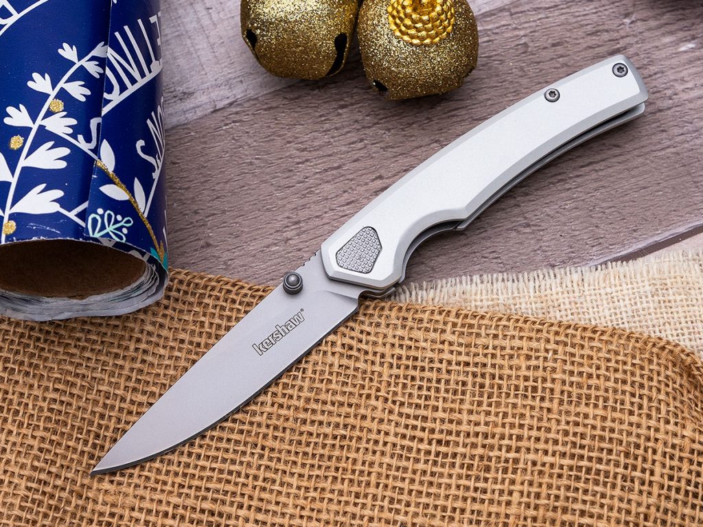 Kershaw Epistle folding knife open on a holiday themed background