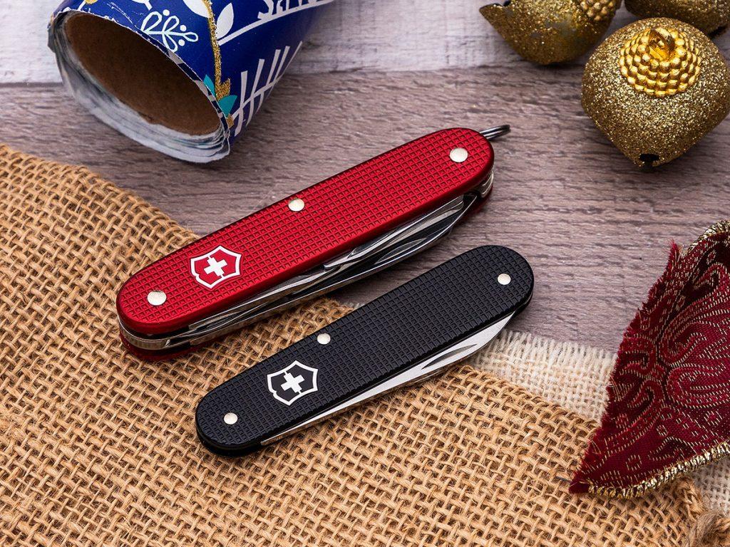 KnifeCenter Exclusive Victorinox Swiss Army Bantam and Pioneer X closed on a holiday themed background