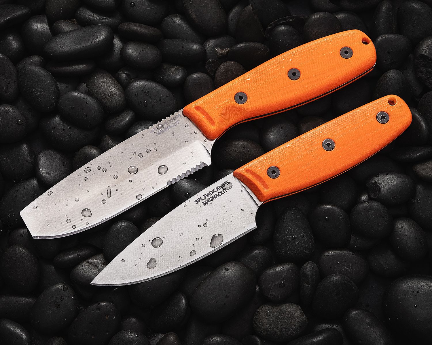 Two Ontario SPL Series Fixed blades resting on rocks