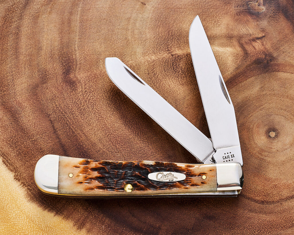 Traditional Trapper knife with two blades partially open on wooden table