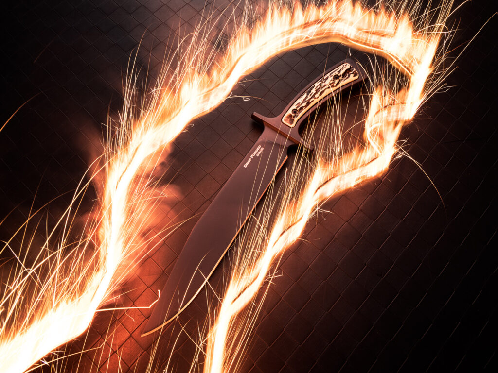 Cold Steel Drop Forged fixed blade knife surrounded by a trail of flames and sparks