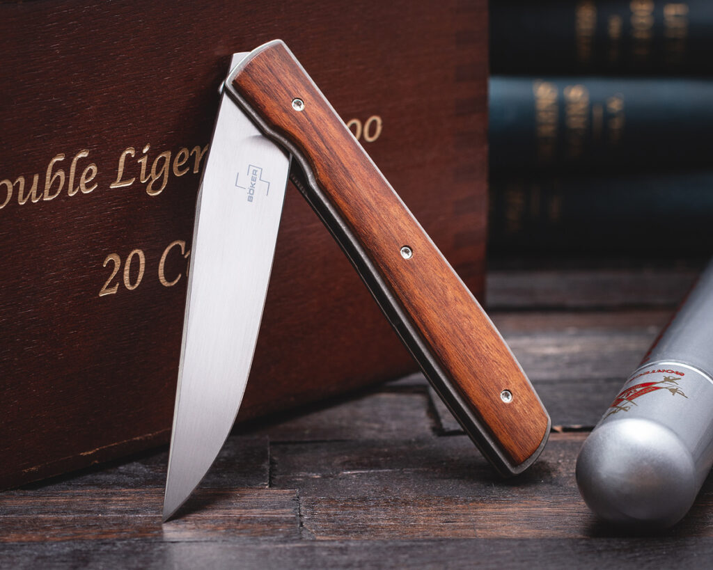 Boker Brad Zinker Urban Trapper folding knife leaning against cigar box
